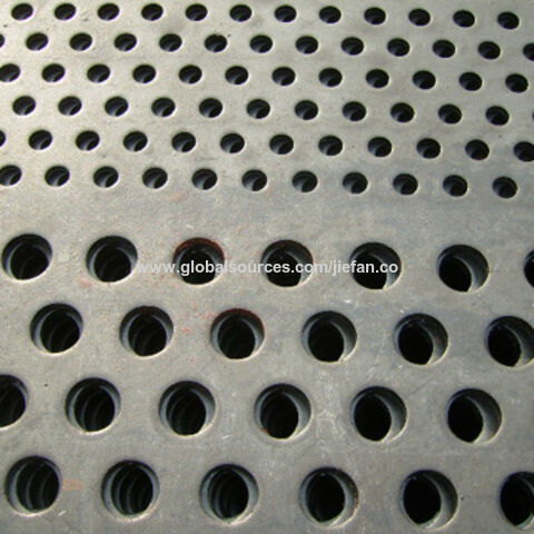 A piece of plastic mesh with small square meshes on gray background.
