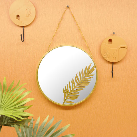 Espejo metálico dorado con detalles de hojas