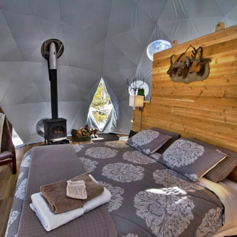 Tienda de cúpula geodésica de lujo para glamping al aire libre en invierno con aislamiento y chimenea