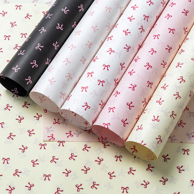 El papel de regalo tiene un tacto lujoso. El material de embalaje está adornado con lazos y hecho de papel Snow Pear.