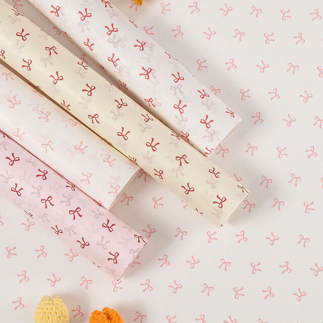 El papel de regalo tiene un tacto lujoso. El material de embalaje está adornado con lazos y hecho de papel Snow Pear.