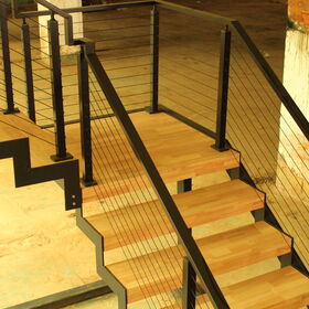 Mit einem umweltbewussten Ansatz balanciert die Treppe elegant die schlanke Stärke von Stahl und die natürliche Wärme von Holz aus.